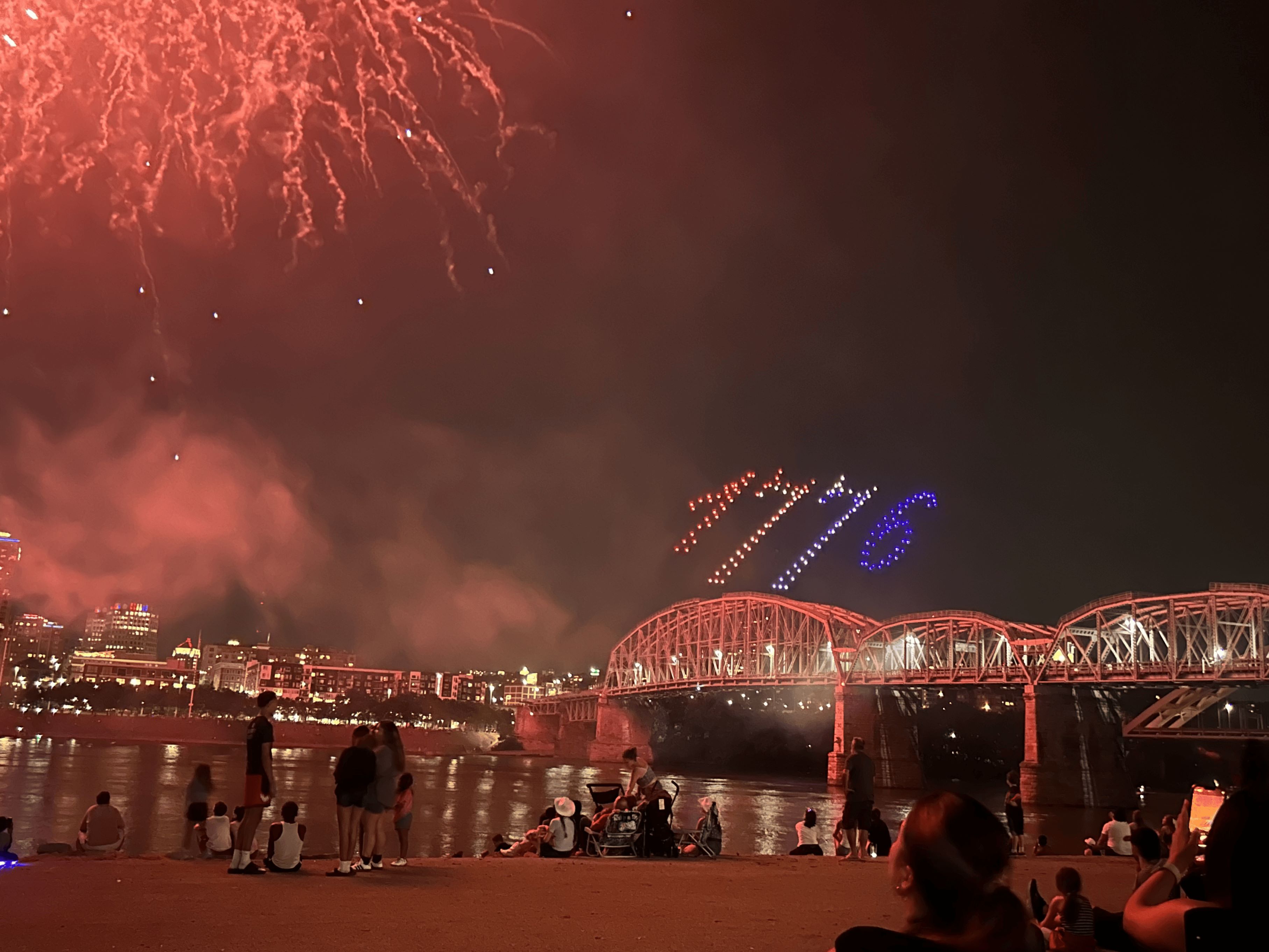 Image of the Cincinnati skyline with red fireworks and drones spelling '1776' in the sky.